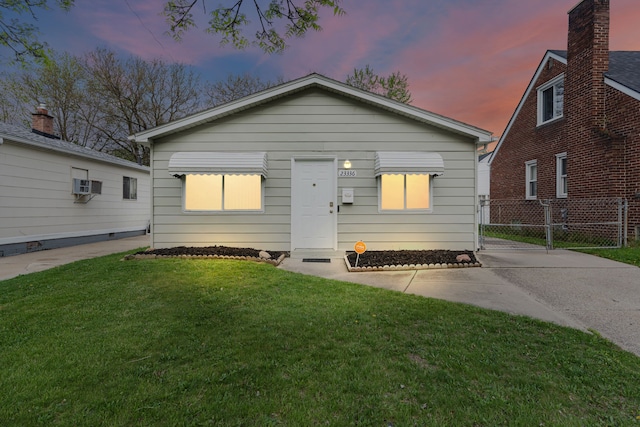 view of front of home featuring an AC wall unit and a gate
