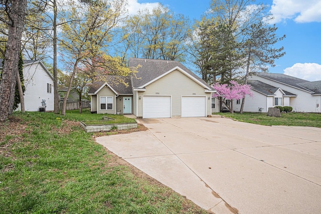 single story home featuring concrete driveway, an attached garage, and a front yard