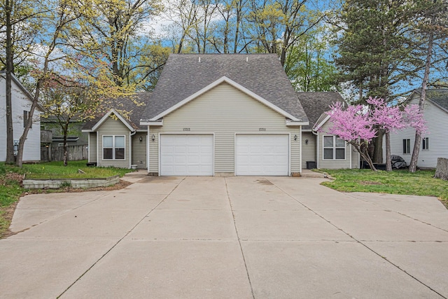 view of front of house featuring concrete driveway, a garage, a shingled roof, and a front lawn