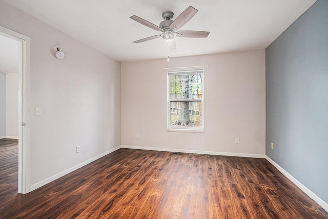 unfurnished room with baseboards, dark wood-style flooring, and ceiling fan