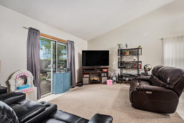 living room with tile patterned floors, high vaulted ceiling, and a glass covered fireplace