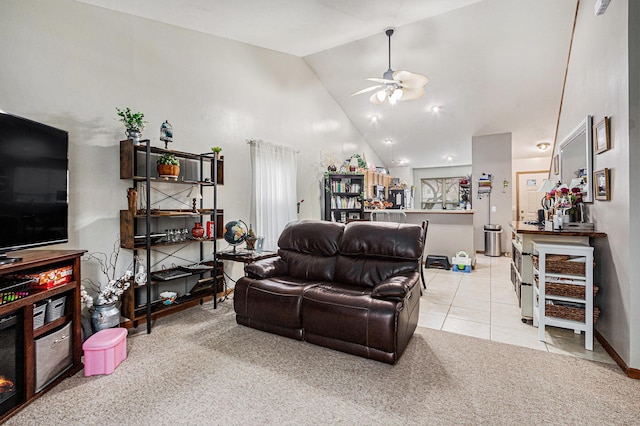 tiled living area featuring carpet, baseboards, ceiling fan, and high vaulted ceiling