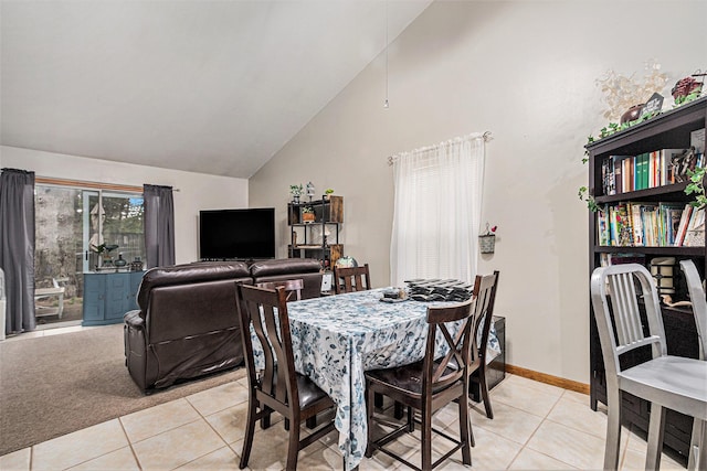 dining area with light tile patterned flooring, baseboards, and high vaulted ceiling