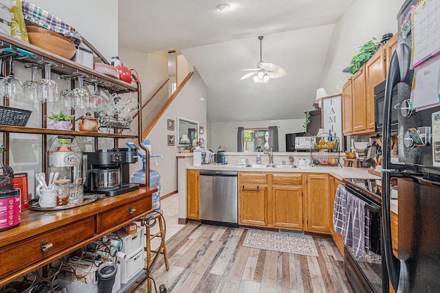 kitchen with ceiling fan, a sink, a peninsula, black appliances, and light wood-type flooring
