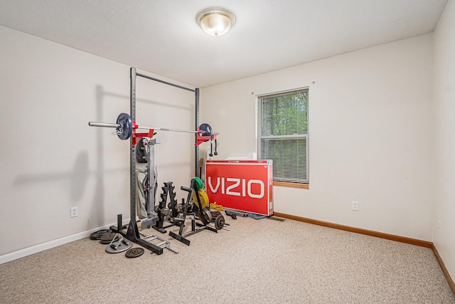 workout room featuring carpet flooring and baseboards