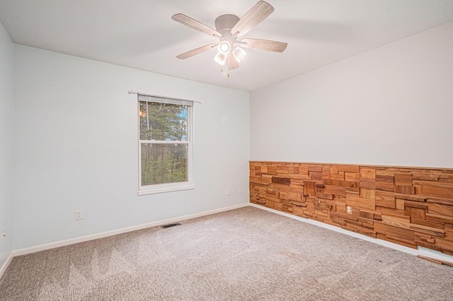 unfurnished room featuring carpet flooring, baseboards, a ceiling fan, and visible vents