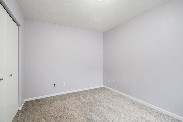 unfurnished bedroom with a closet, baseboards, and carpet