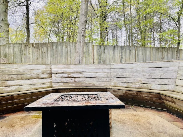 exterior space featuring an outdoor fire pit, fence, and a patio