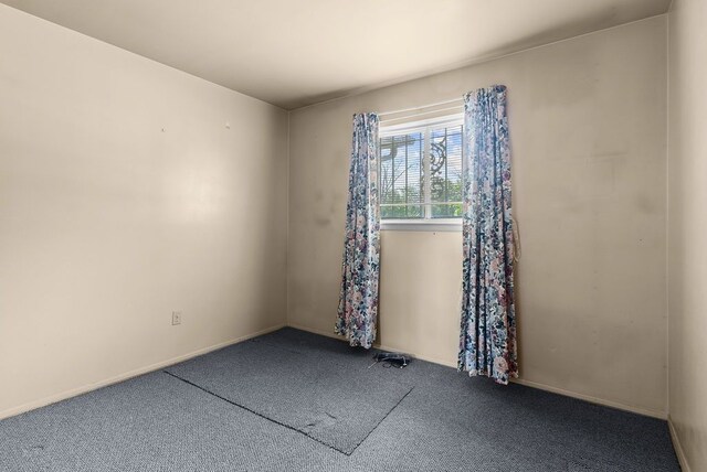 carpeted spare room with baseboards