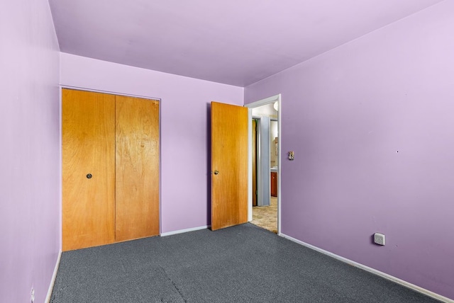 unfurnished bedroom featuring carpet flooring, baseboards, and a closet