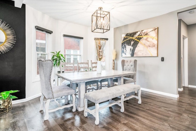 dining space with wood finished floors, baseboards, and a chandelier