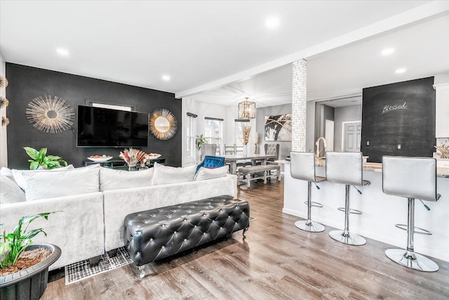 living area with baseboards, beamed ceiling, recessed lighting, and wood finished floors