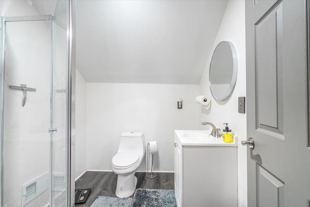 bathroom with toilet, wood finished floors, a stall shower, lofted ceiling, and vanity