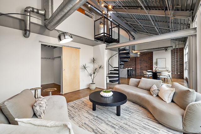 living area with baseboards, stairs, finished concrete floors, and a towering ceiling