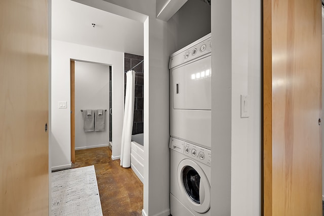 laundry room featuring laundry area, stacked washer / dryer, and baseboards