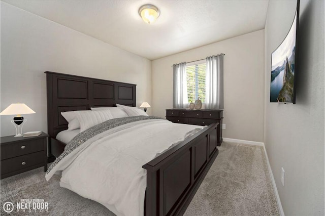 bedroom with light colored carpet and baseboards
