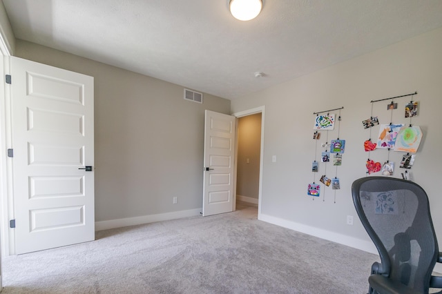 carpeted office space with baseboards and visible vents