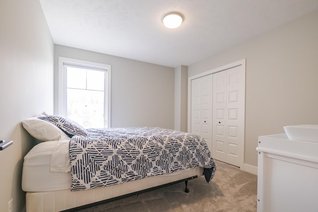 bedroom with carpet flooring, a closet, and baseboards