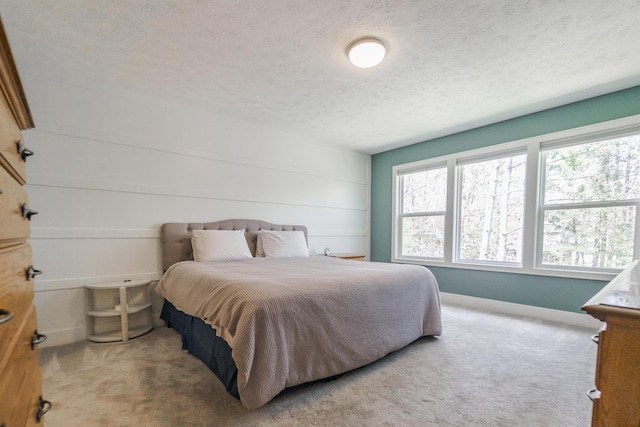 bedroom with a textured ceiling, carpet flooring, and baseboards