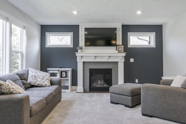 living area with a tile fireplace, recessed lighting, and carpet