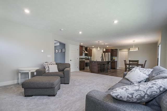 living area with baseboards, dark carpet, and recessed lighting