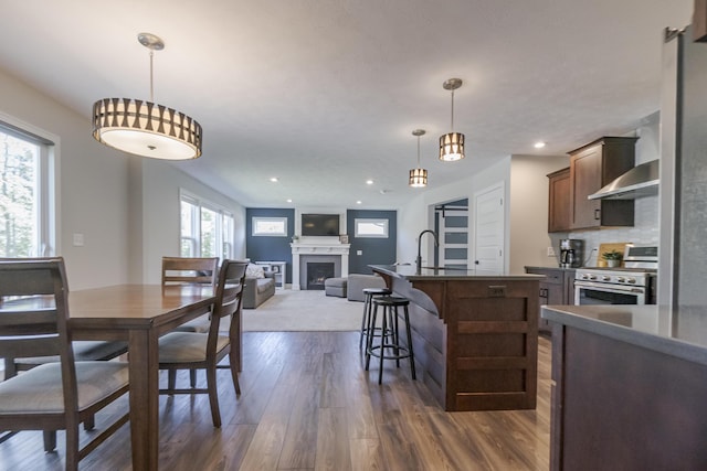 dining room featuring a fireplace, dark wood-style floors, and recessed lighting