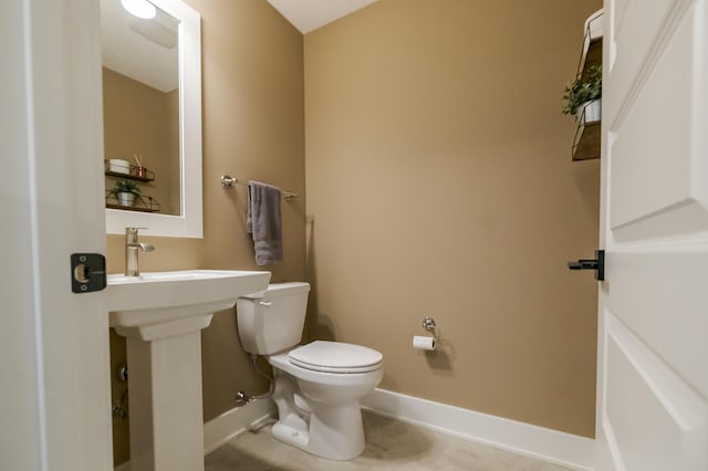 bathroom with toilet and baseboards