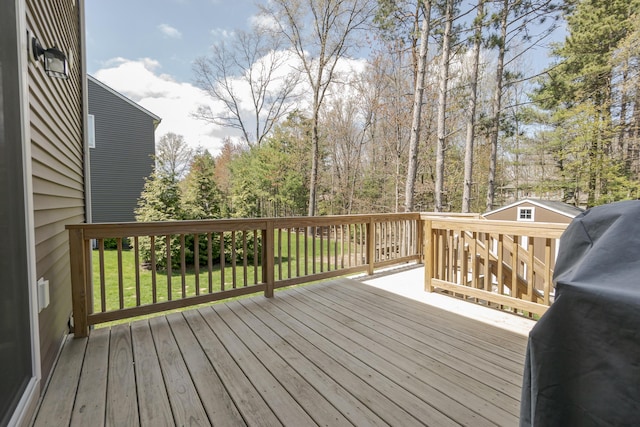 wooden deck featuring area for grilling and a lawn