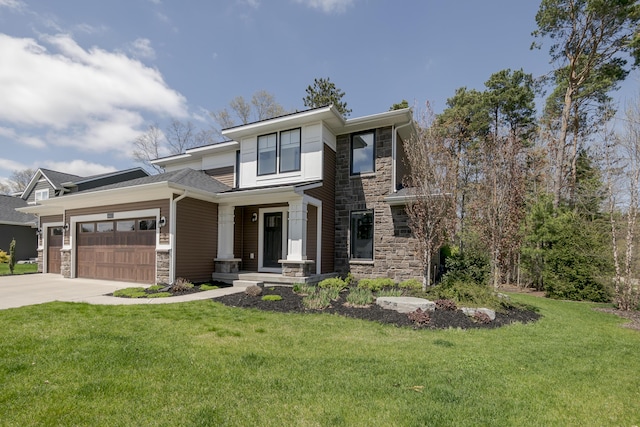 prairie-style home with concrete driveway, an attached garage, stone siding, and a front yard