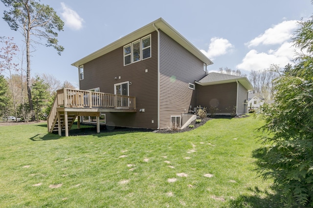 rear view of house featuring a lawn, stairs, and a deck