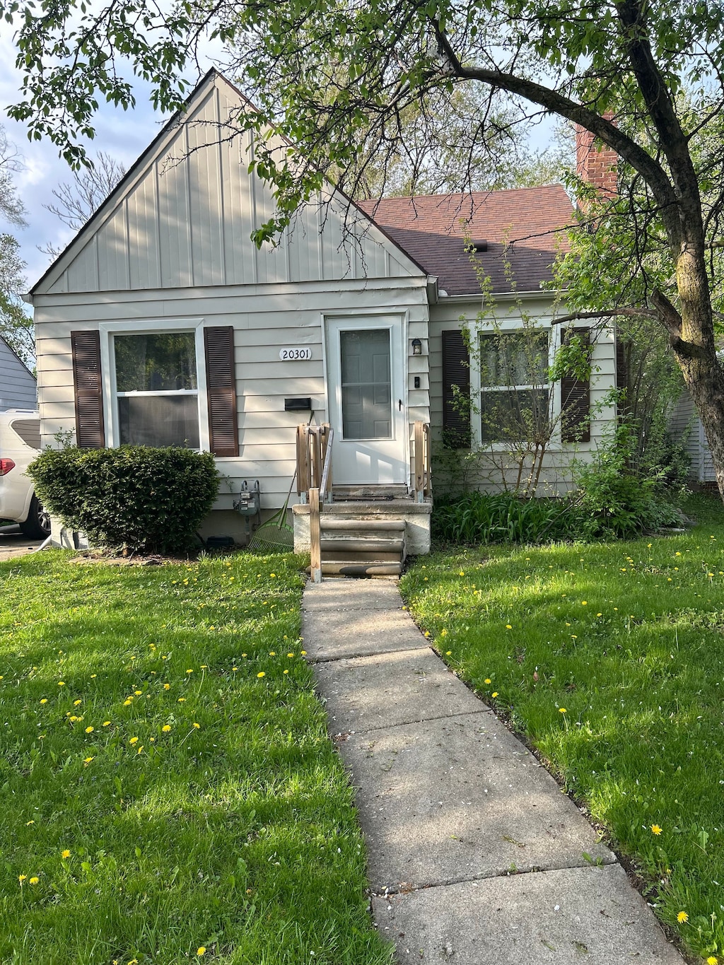 bungalow featuring a chimney and a front lawn