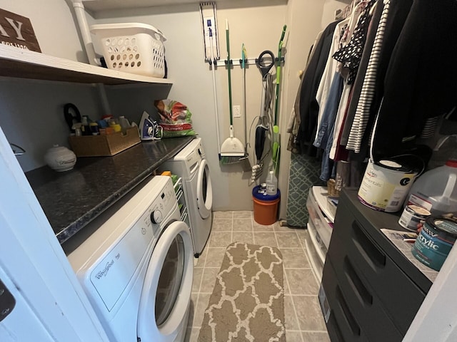 washroom featuring washing machine and clothes dryer, light tile patterned floors, and laundry area