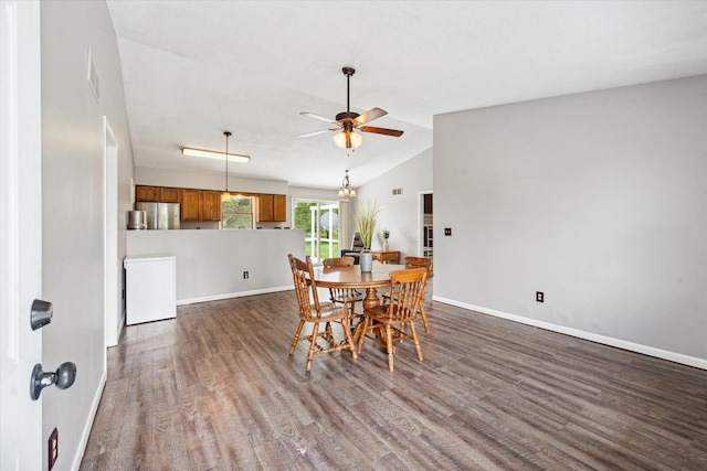 dining room with baseboards, vaulted ceiling, dark wood-style flooring, and a ceiling fan