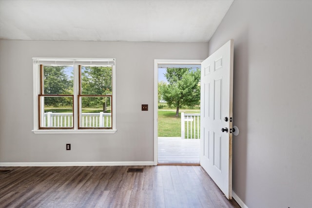 doorway with baseboards, visible vents, and wood finished floors