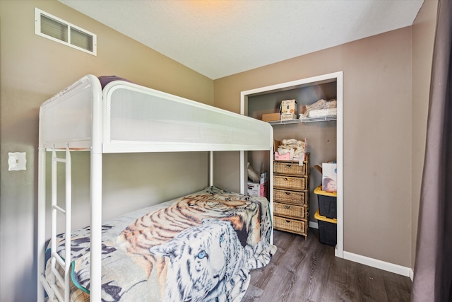 bedroom featuring baseboards, visible vents, and wood finished floors