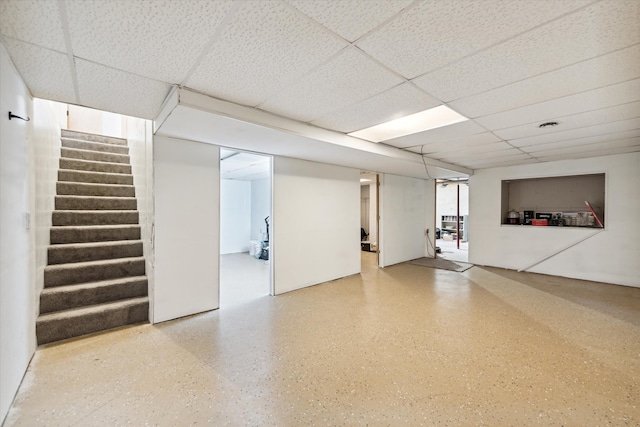 below grade area with a drop ceiling and stairs