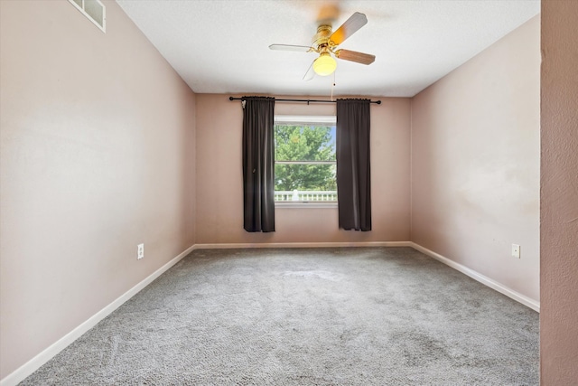 unfurnished room featuring carpet flooring, visible vents, baseboards, and a ceiling fan