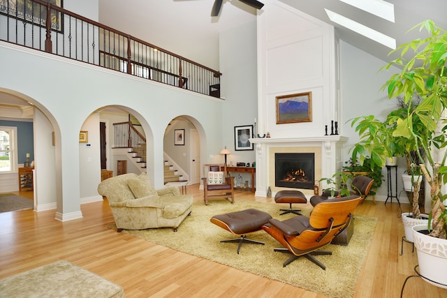 1256 Lenhill Ct, Bloomfield Hills, MI 48304 - living area with wood finished floors, stairs, a skylight, a high ceiling, and arched walkways