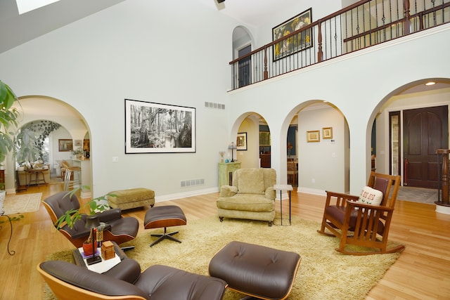 1256 Lenhill Ct, Bloomfield Hills, MI 48304 - living room with a towering ceiling, arched walkways, wood finished floors, and baseboards