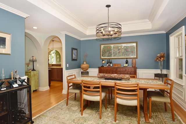 1256 Lenhill Ct, Bloomfield Hills, MI 48304 - dining room featuring a chandelier, light wood-type flooring, a tray ceiling, arched walkways, and a wainscoted wall