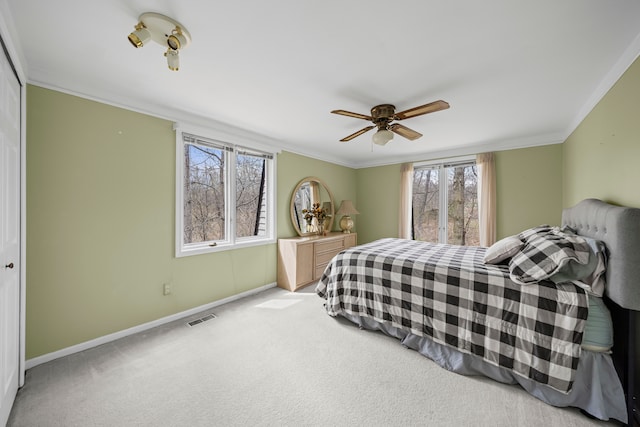 bedroom featuring baseboards, multiple windows, light carpet, and visible vents