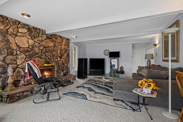 carpeted living area with a fireplace and beamed ceiling