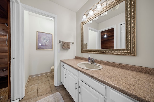 bathroom with vanity, toilet, baseboards, and tile patterned flooring
