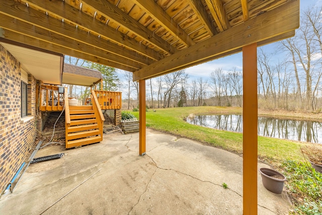 view of patio / terrace with a deck with water view and stairs