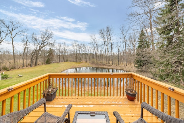 wooden terrace featuring a water view and a lawn