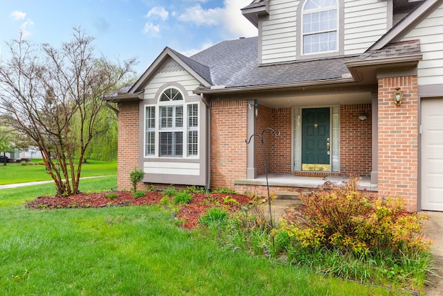 entrance to property with brick siding, a shingled roof, a lawn, and a porch