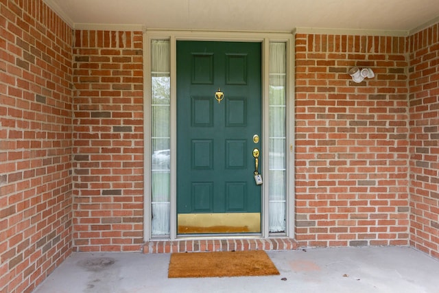 view of exterior entry with brick siding