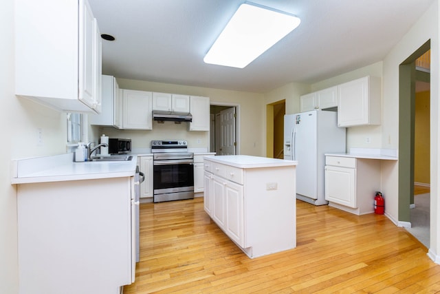 kitchen with appliances with stainless steel finishes, white cabinets, light wood-type flooring, and a sink