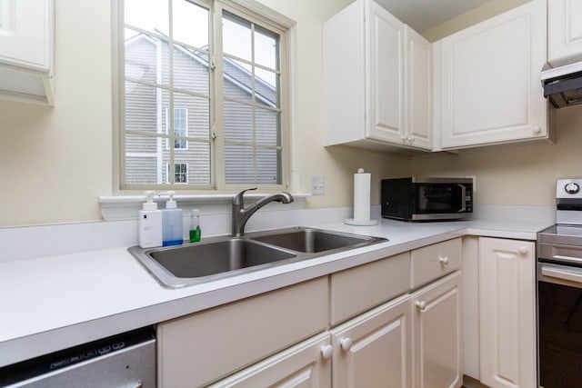 kitchen featuring stainless steel appliances, a sink, white cabinets, under cabinet range hood, and light countertops