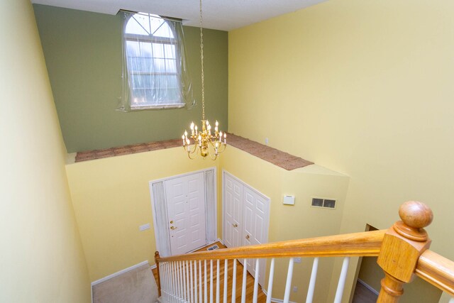 stairway featuring a chandelier and baseboards